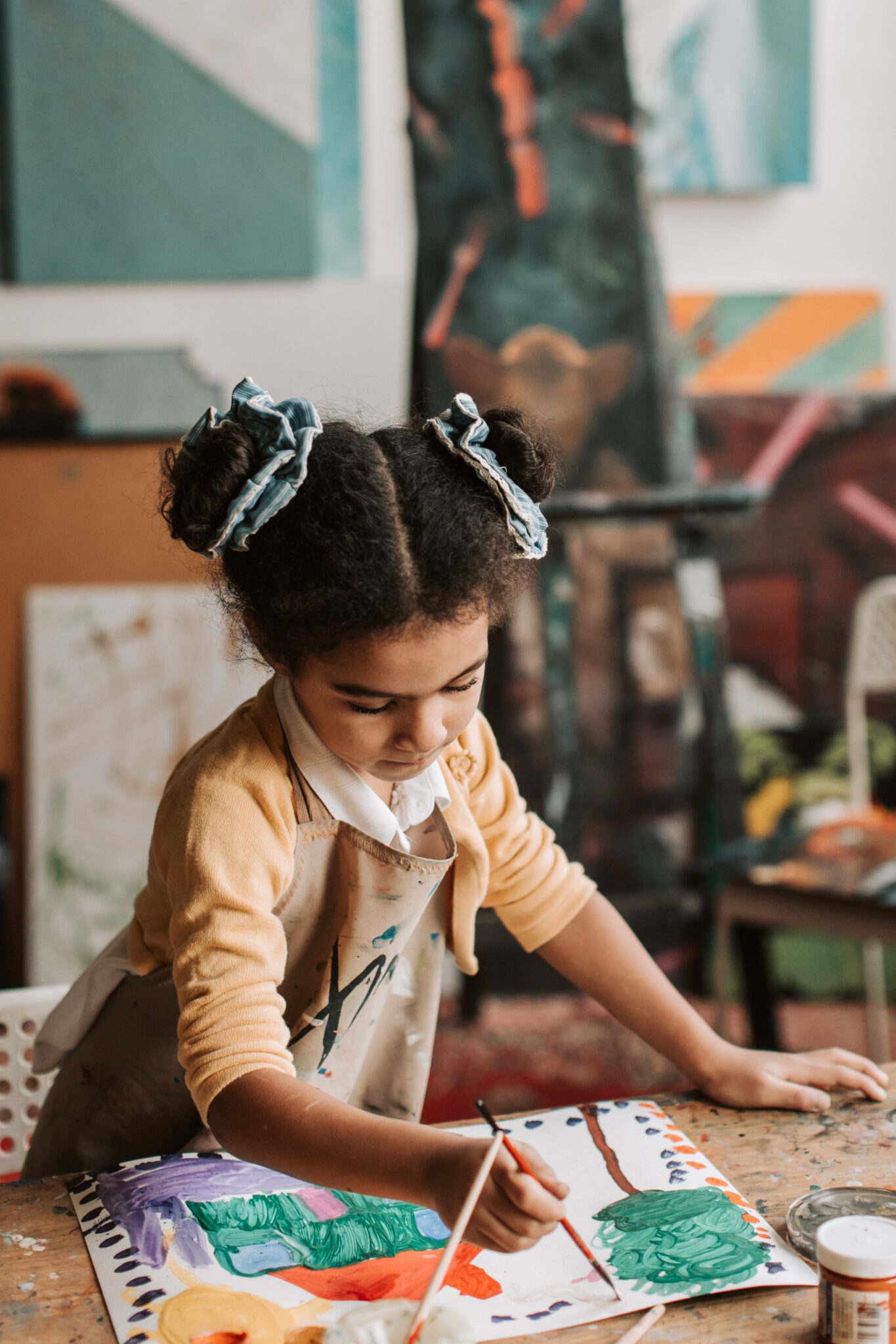 A young girl immersed in painting, exploring her creativity in an art studio.